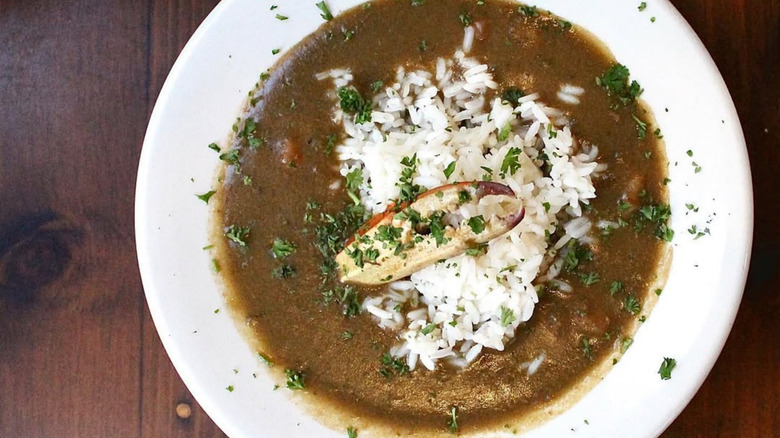 Bowl of Mena's Palace seafood gumbo topped with rice and parsley