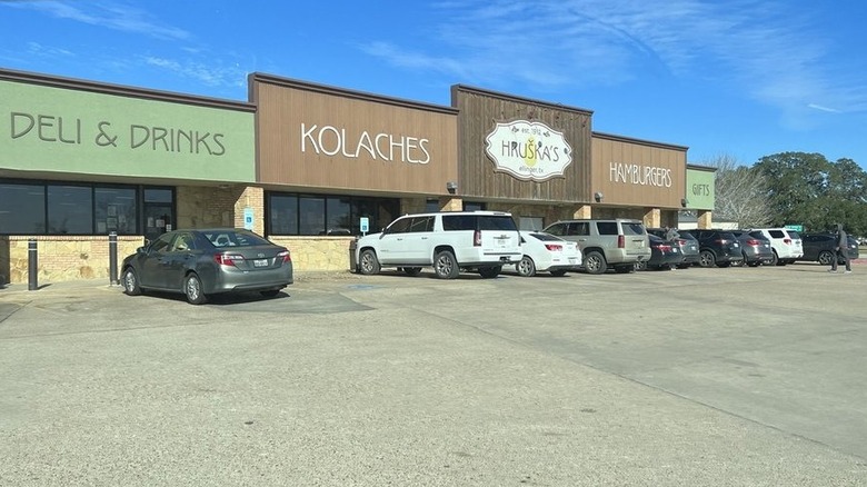 Cars and SUVs parked in a lot in front of a large convenience store.