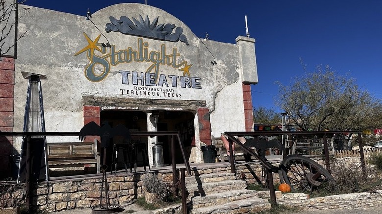 A rundown, concrete building with Starlight Theatre painted on the facade