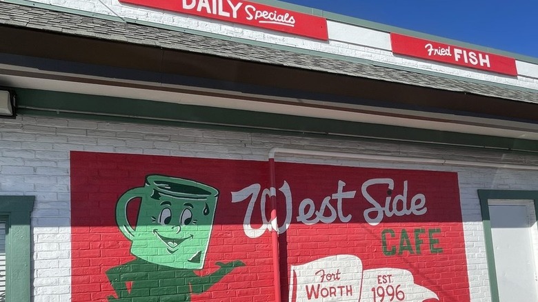 White exterior of West Side Cafe with red signs