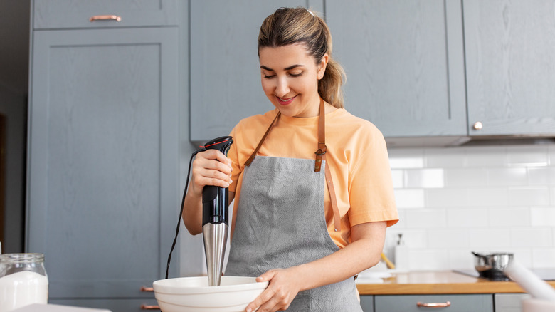 Woman using an immersion blender