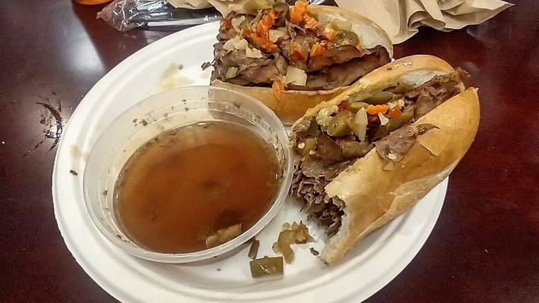 Two Italian beef sandwiches with a side of au jus at Romanelli's Italian Deli