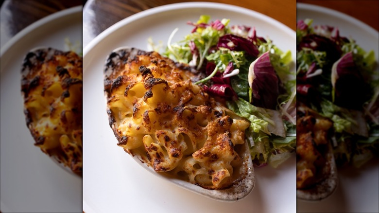 Small dish of macaroni and cheese next to salad