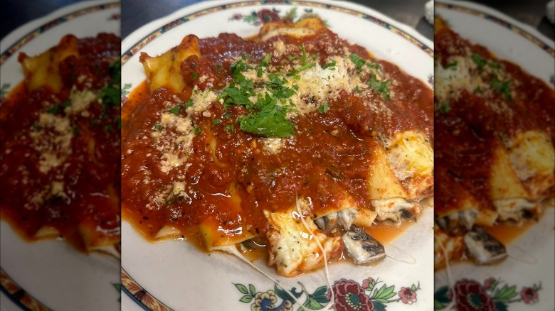 Manicotti stuffed with braised lamb and mushrooms on plate