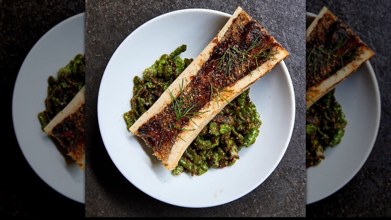 Bone marrow in a white bowl with greens