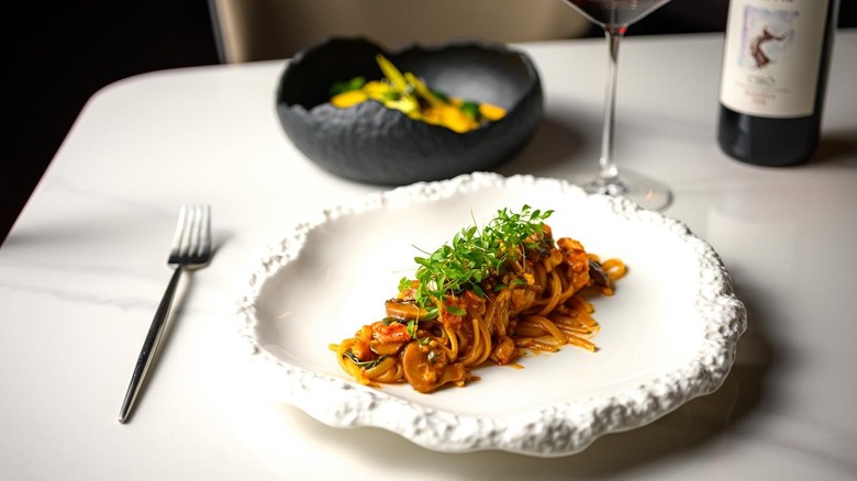 Linguine on white plate with glass of wine