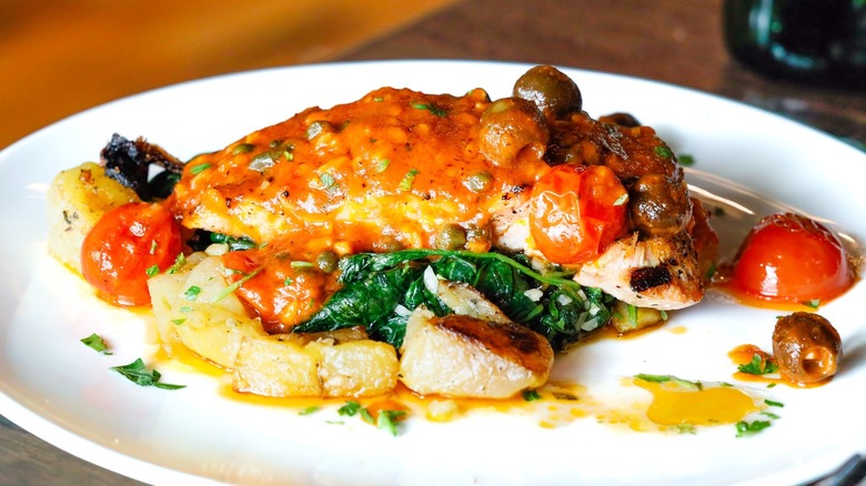 Salmon alla Livornese on a white plate