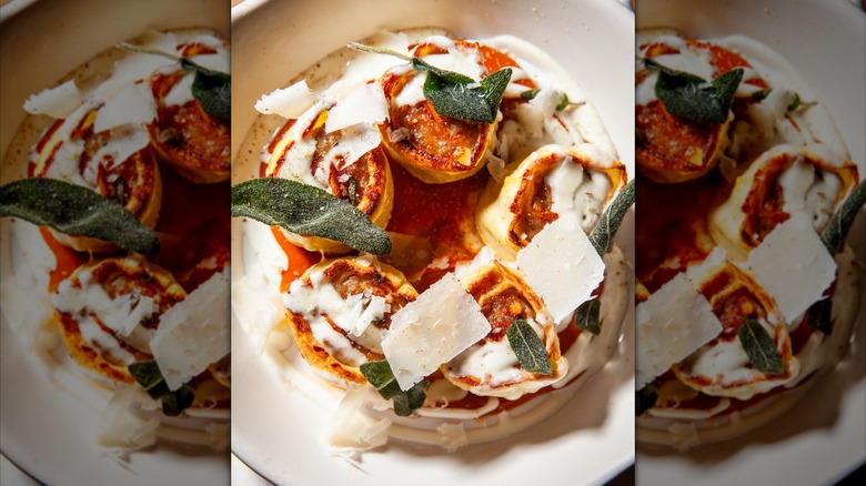 Pasta decorated with basil, sauce, and Parmesan