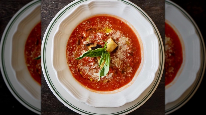 Tomato soup in a white bowl with parmesan
