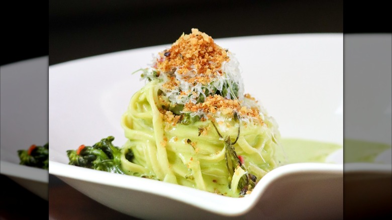 Creamy spaghetti with pesto topped with bread crumbs