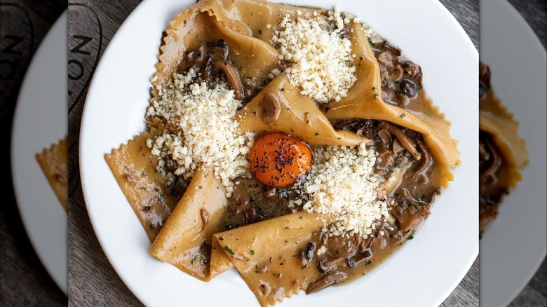 Fazzoletto or handkerchief pasta, with umami mushrooms and butter, topped with an egg yolk