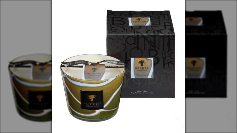 Glass candle next to black packaging