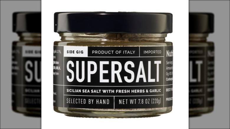 black jar containing Sicilian sea salt with garlic and herbs