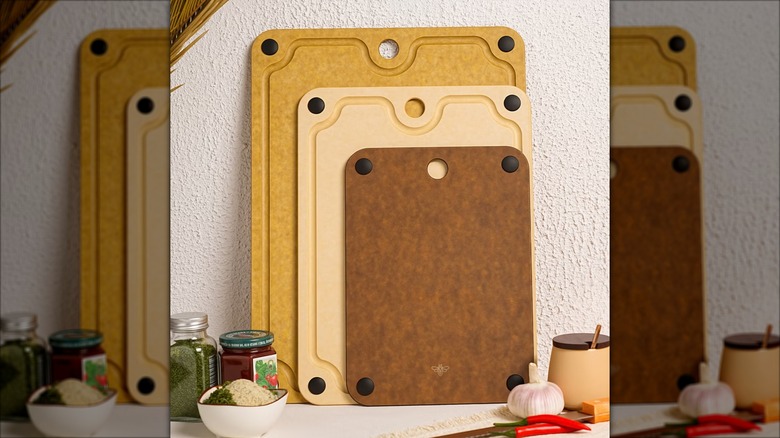 Three wood colored cutting boards leaning against a wall.