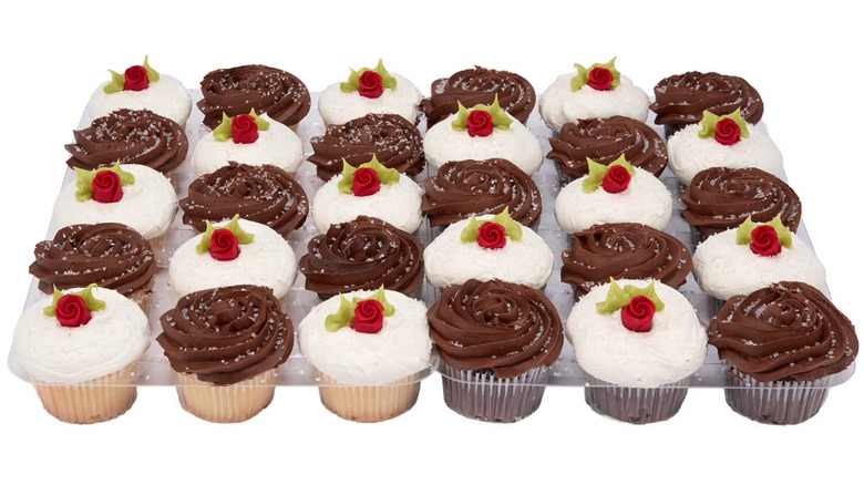 Assortment of chocolate and vanilla cupcakes with rose decorations.