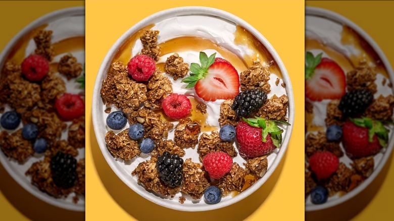 Bowl of Purely Elizabeth Original Organic Ancient Grains Granola with yogurt, honey, and fruit