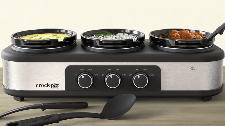 Trio of mini crockpots filled with various foods