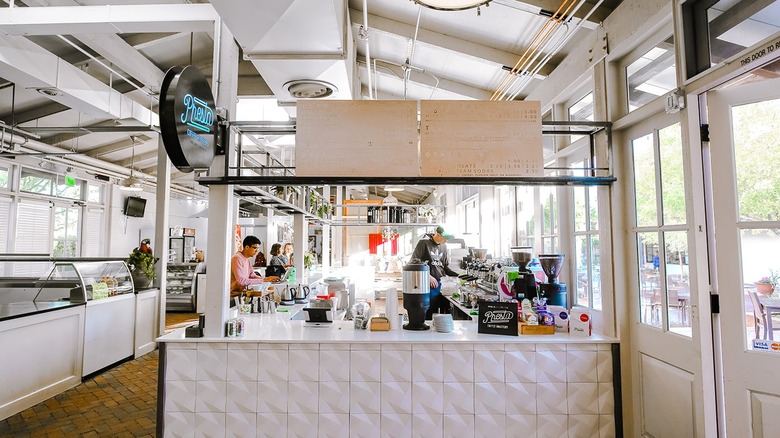 Customers stand at the counter in Presta as a barista makes coffee