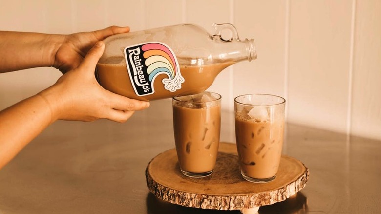 Barista pours iced coffee from a Rainbeau Jo's glass jug
