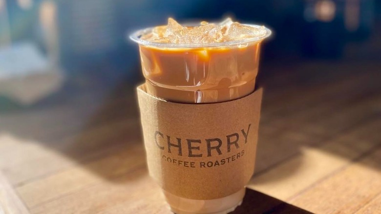 An iced coffee with a Cherry Coffee Roasters cup sleep