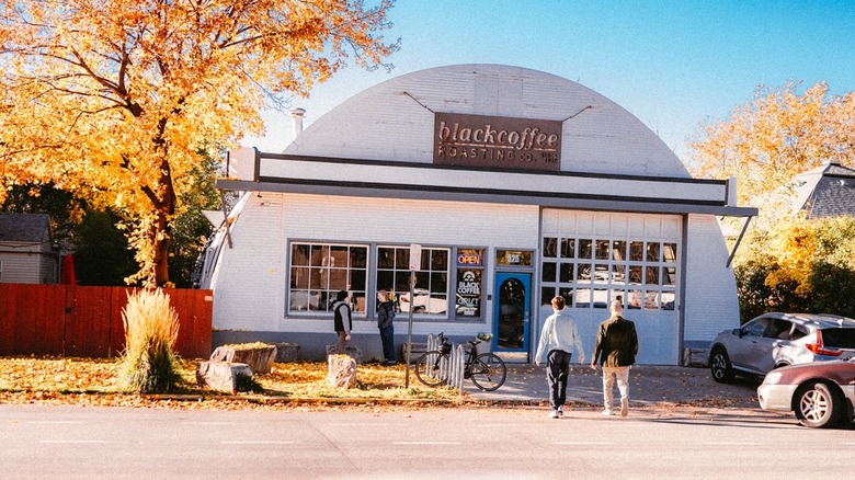People cross the street to enter the Black Coffee Roasting Company café