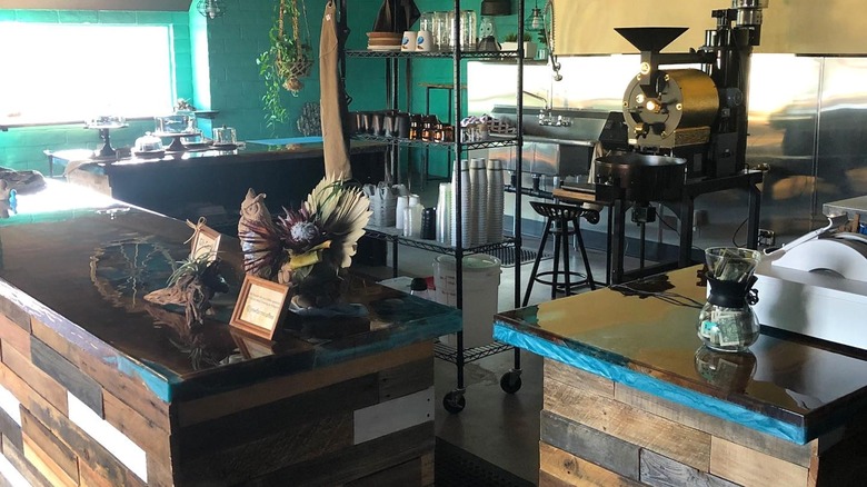 A roaster and other coffee-making items sit behind a café counter