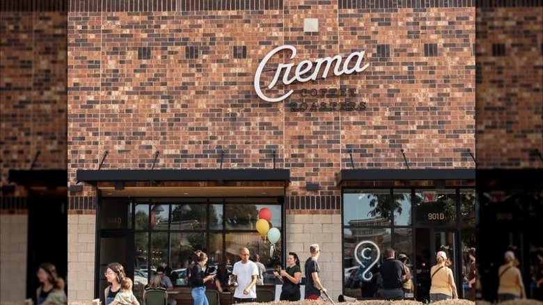 View of the entrance of Crema Coffee Roasters as customers enter and leave