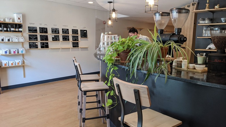 Barista works from behind a black coffee bar