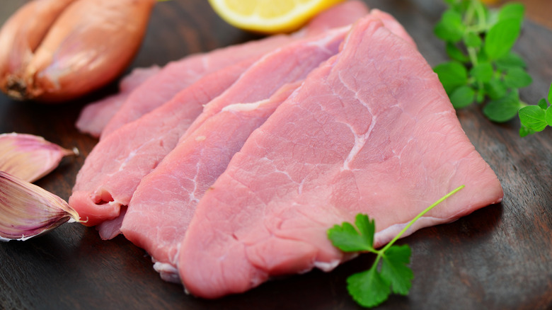 Sliced raw veal on wood board