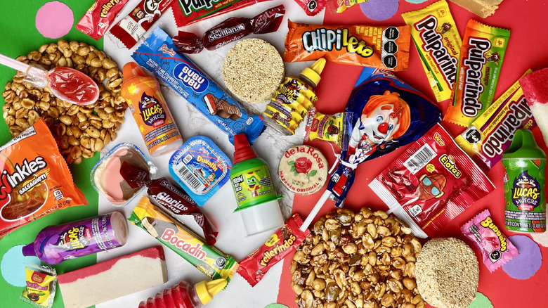 A pile of a variety of Mexican candies on a green, white, and red background