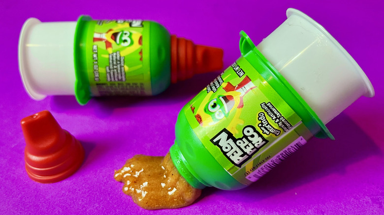 An open container of Pelon Pelo Rico pushing out liquid tamarind gel candy