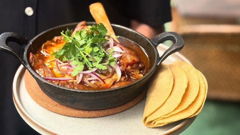 Lamb birria served in a bowl with tortillas from Reyes Mezcaleria