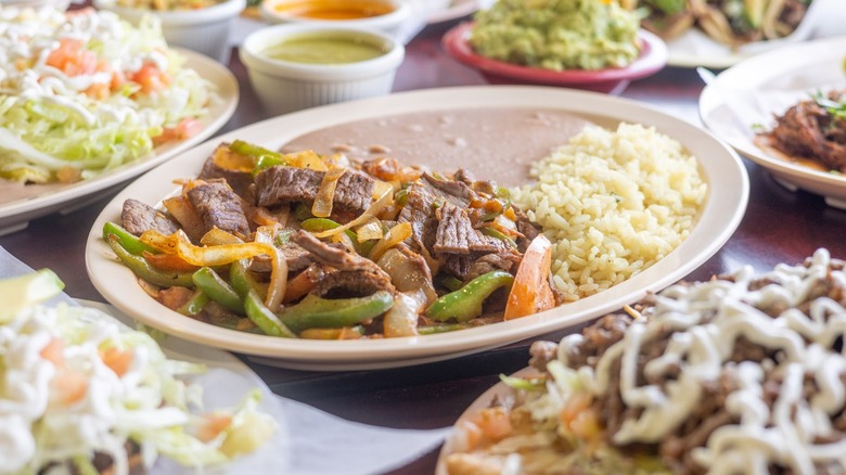 fajitas and Mexican food on oval plates on a table