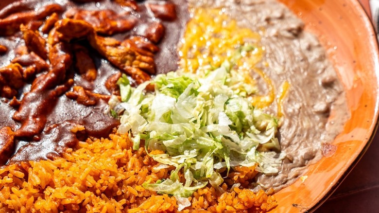 chicken mole with rice and beans on plate