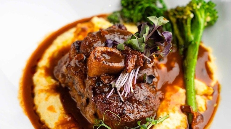 a fine-dining Mexican meat dish with broccoli over sauce and mashed potatoes