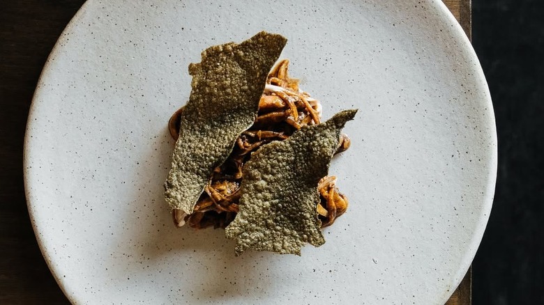 squid, white asparagus, and jicama in aguachile presented in fine-dining manner on plate