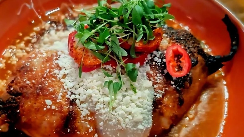 Close up of chile relleno, poblano chile stuffed with roasted vegetables topped with smoked gouda on plate