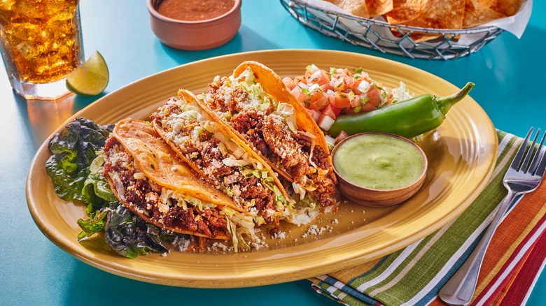 tacos, green chile, and salsa on plate