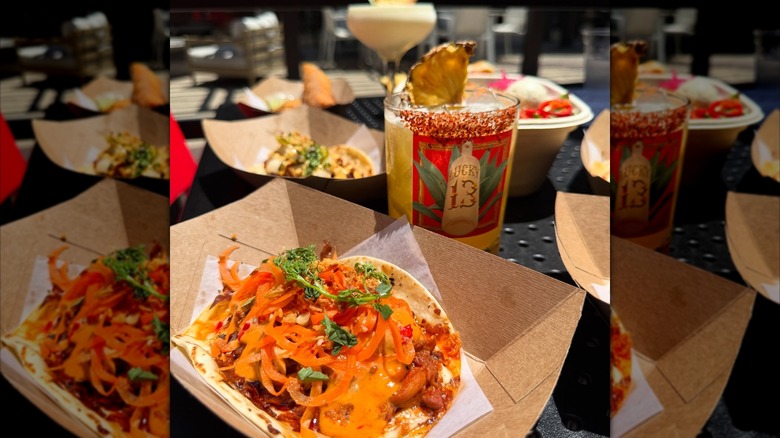 Soft shell tacos in cardboard trays on table with cocktails