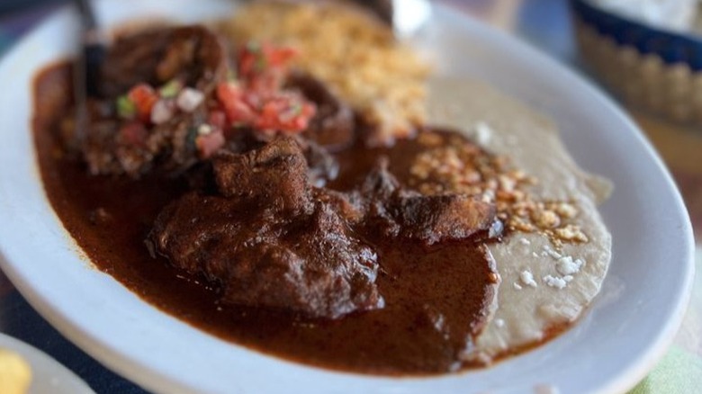 a plate of chamorro with rice and beans