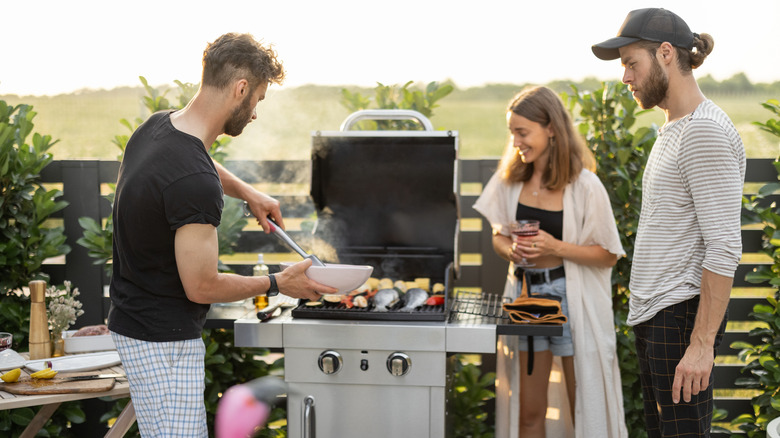 people cooking on outdoor grill