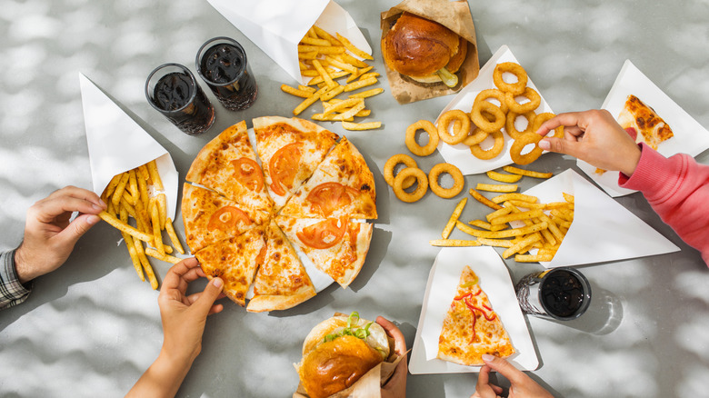 People reaching for fast food items