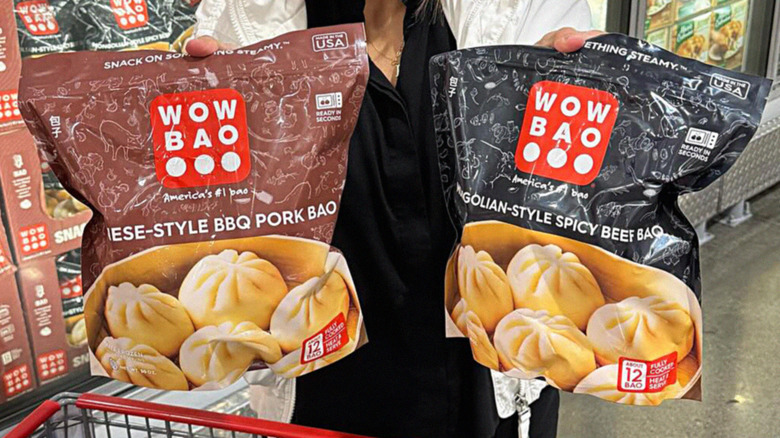 hands holding Wow Bao bags in freezer aisle