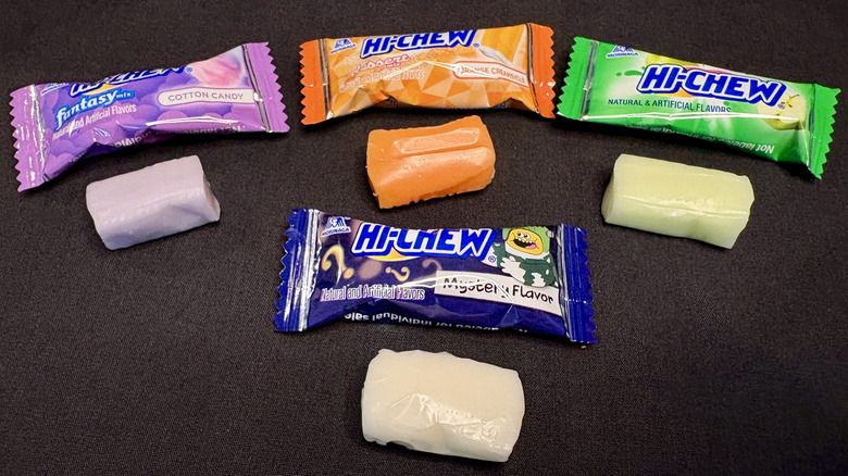 four Hi-Chews with wrappers on black background