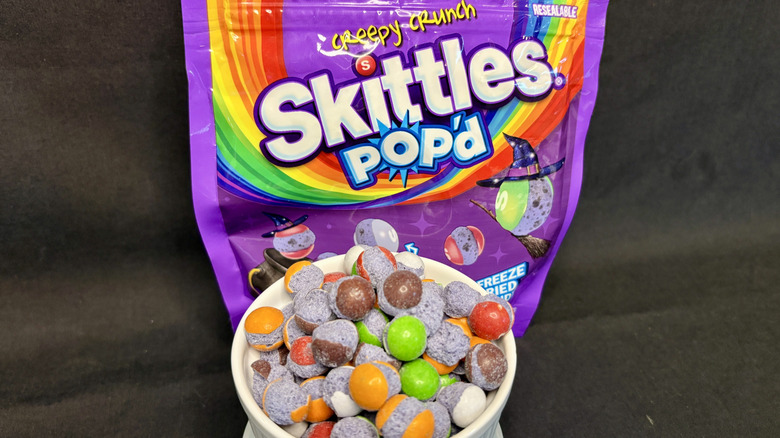 purple bag of Skittles Crunch with bowl of candy in foreground