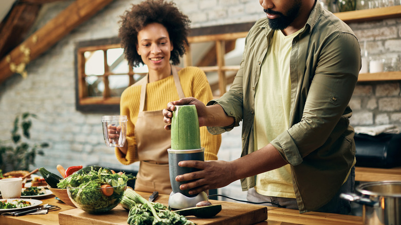 couple blending green smoothie