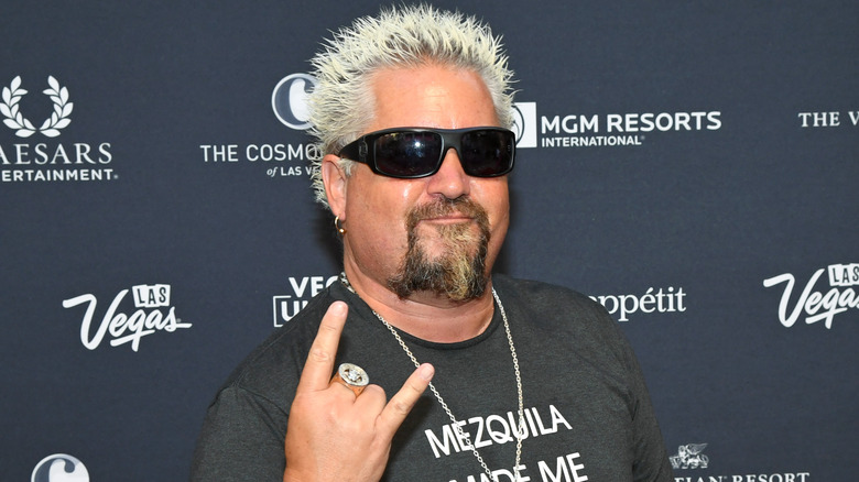 Guy Fieri making the "rock-on" gesture