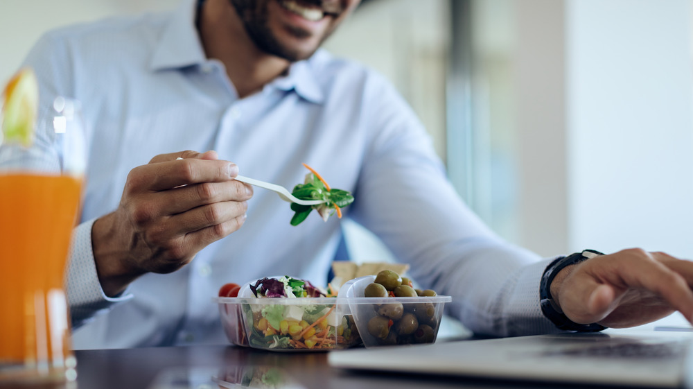 man eating lunch at his desk