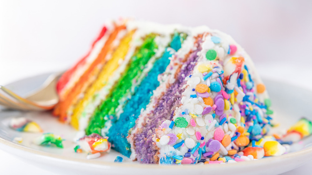 layered rainbow cake with frosting