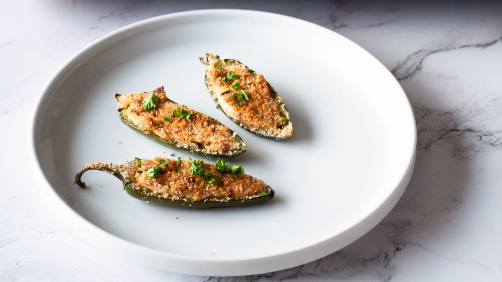 jalapeno poppers with bread crumbs and bacon on white plate